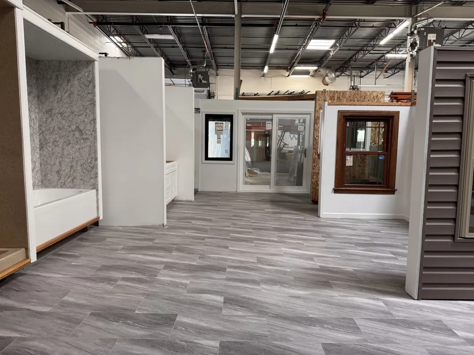 Inside the Excel showroom in Tinley Park — solid-surface shower displays, doors, and siding samples