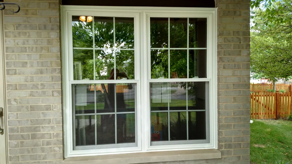 Twin double-hung windows with colonial grids on a brick home, Chicagoland south suburbs