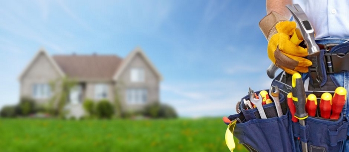 Chicago Home Improvement Contractor contractor with tool belt standing front of house